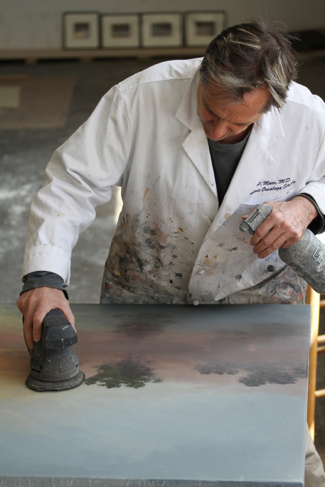 Color photograph of Stephen Hannock working on a painting. 