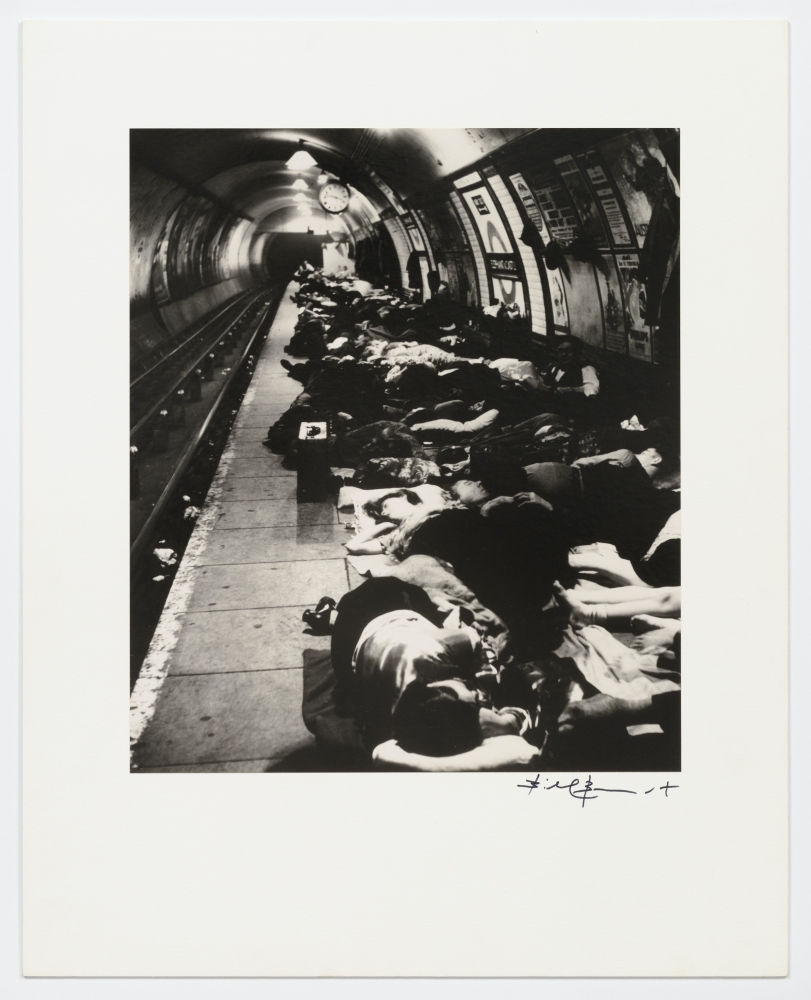 Black and white silver gelatin print of people sheltering in the underground train station (The Tube).