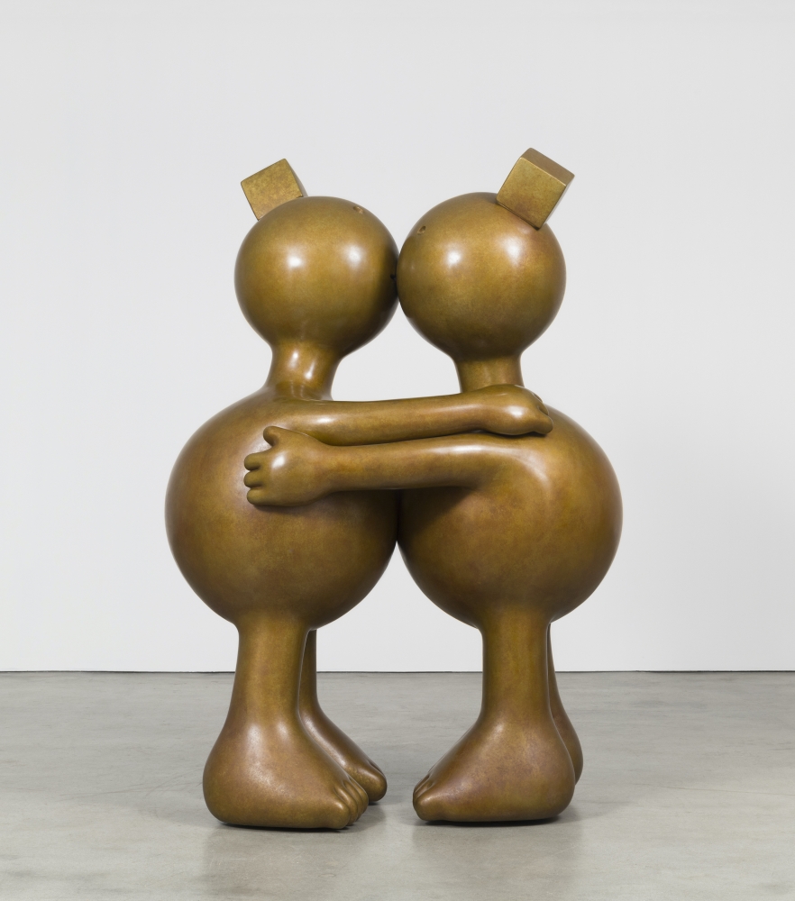 Two large bronze and rotund sculptures kissing by Tom Otterness.