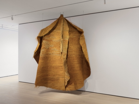 Installation view of orange hanging textile piece by Magdalena Abakanowicz