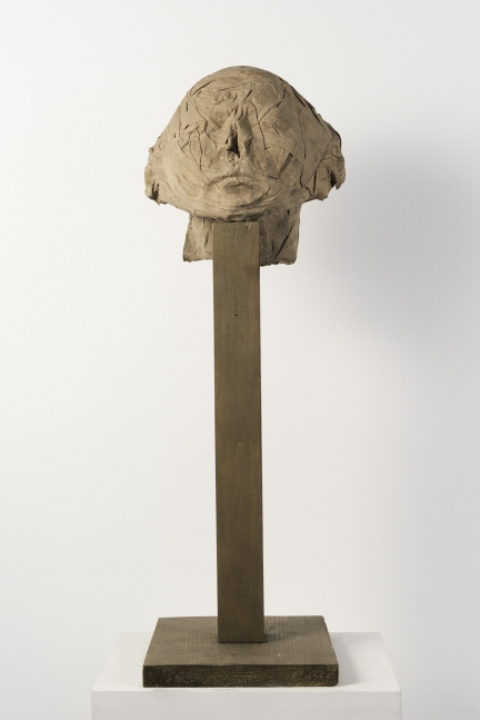 Cotton, resin, and sand sculpture of a head on a pedestal