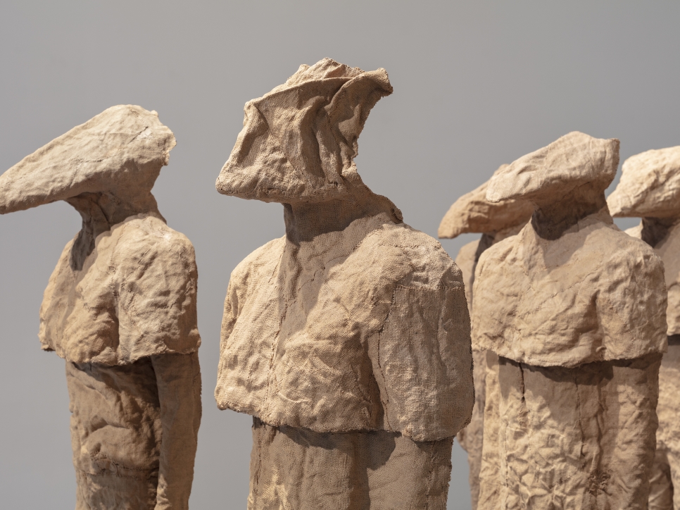 Detail view of multiple burlap and resin figures with different heads by Magdalena Abakanowicz