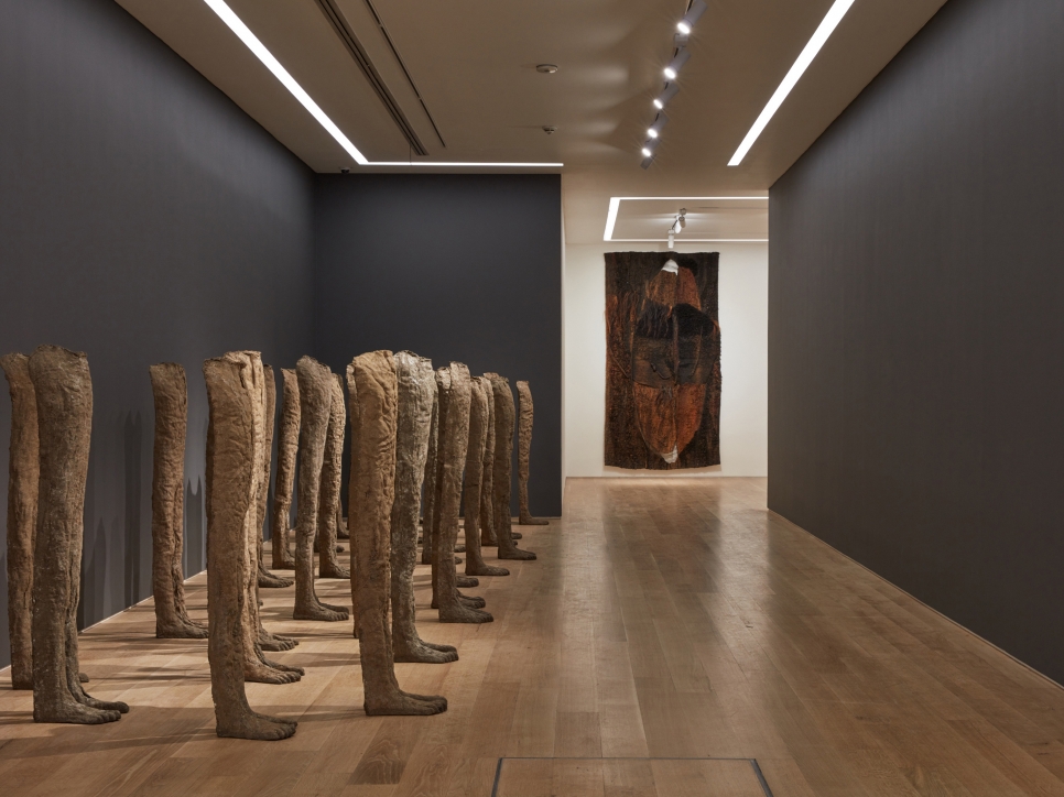 Installation view of burlap and resin sculptures and a textile work by Magdalena Abakanowicz